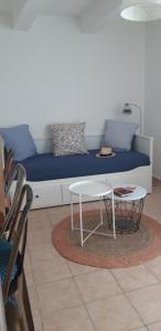 Una sala de estar con un sofá azul y una mesa. en ELSA., en La Ciotat