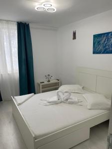 a white bed with a bow on it in a bedroom at Apartament Olimp in Olimp