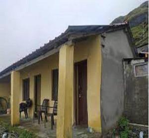 a house with a dog standing outside of it at Akash Ganga - Backpackers Den by StayApart in Rudraprayāg