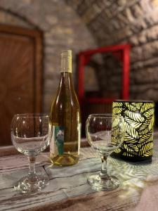een fles wijn en twee wijnglazen op een tafel bij Chill Apartman in Balatonfüred