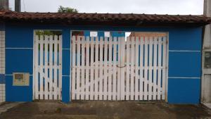une maison bleue avec une porte blanche devant elle dans l'établissement Casa em Mongaguá, próximo a Plataforma de Pesca, à Mongaguá