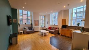 uma sala de estar com um sofá e uma mesa em Spacious, bright and airy city centre flat. Unique converted Mill. em Manchester