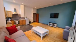 a living room with a couch and a table at Spacious, bright and airy city centre flat. Unique converted Mill. in Manchester
