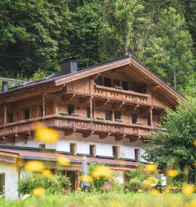 - un grand bâtiment en bois avec un balcon dans l'établissement Das Lindtal - Appartements, à Finkenberg