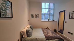 a bedroom with a bed in a room with a window at Spacious, bright and airy city centre flat. Unique converted Mill. in Manchester