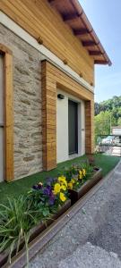 a garden with flowers in front of a building at Graziosa, Casetta in Valgerola in Rasura