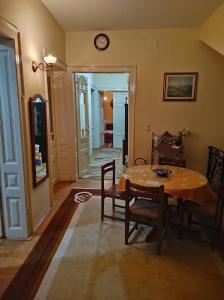 een eetkamer met een tafel en stoelen en een klok bij Guest House Prilep in Prilep