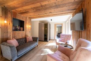 a living room with a couch and two chairs at Das Lindtal - Appartements in Finkenberg