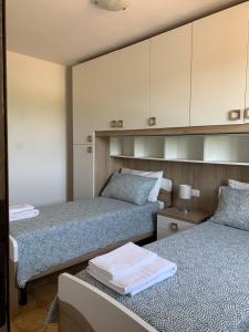 dwa łóżka w pokoju z białymi szafkami w obiekcie IL MESSINO w mieście Montevarchi