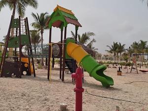 a playground with a slide on a beach at almuzn in Salalah