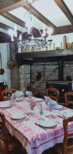 une table à manger avec un tissu de table rose et blanc dans l'établissement Hostellerie des voyageurs, à Cassagnes-Bégonhès