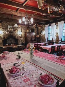 - une salle à manger avec une grande table et des roses dans l'établissement Hostellerie des voyageurs, à Cassagnes-Bégonhès