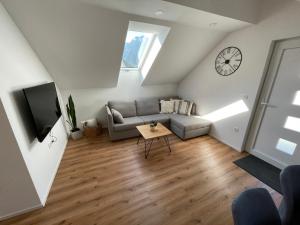 ein Wohnzimmer mit einem Sofa und einer Uhr an der Wand in der Unterkunft Apartma Guide 360 in Bovec
