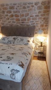 a bed in a room with a brick wall at Apartman Zlatan in Drniš