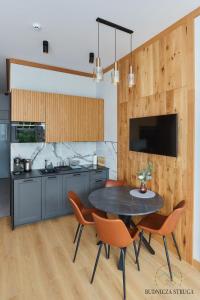a kitchen with a table and chairs in a room at Apartament Budnicza Struga z Sauną i Parkingiem - 5D Apartamenty in Karpacz