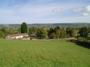 a large green field with a barn in the background at Ashton Cottages in Wedmore