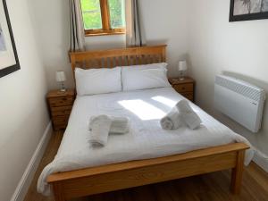 a bedroom with a bed with towels on it at Ashton Cottages in Wedmore