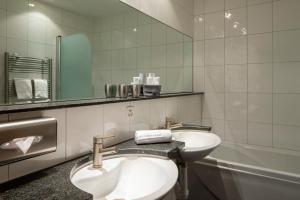 bagno con servizi igienici, lavandino e specchio di Cristallo Arosa Hotel a Arosa