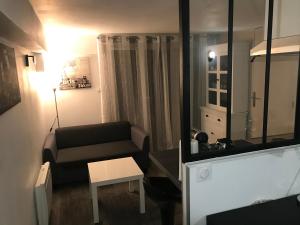 uma sala de estar com um sofá e uma mesa em Joli Studio/T1 Rennes em Rennes