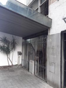 una entrada a un edificio con una puerta y una palmera en Los Marinos en Rosario