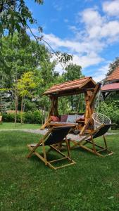 a couple of chairs and a gazebo in the grass at B&B Plitvice Holiday Lodge in Plitvička Jezera