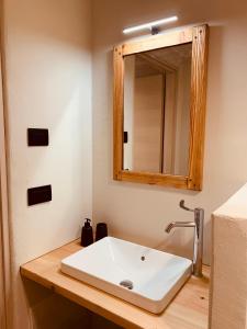 bagno con lavandino bianco e specchio di La Tsambra-Le Four des Alpes a Rhemes-Saint-Georges