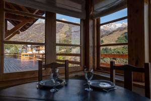 uma sala de jantar com uma mesa e vista para as montanhas em Hostería del Cerro em San Carlos de Bariloche