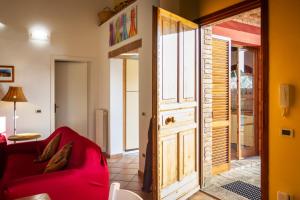 蒙帖斯庫達祐的住宿－CASE&COLLINE Villa Grazia，客厅配有红色沙发和门