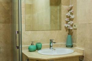 a bathroom sink with two vases and a mirror at Toledo Enamora con Garaje in Toledo