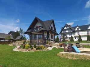 a house with a playground in front of it at Domek Gerlach Bańska Wyżna in Bańska Wyżna