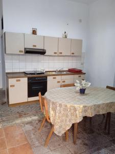 Il comprend une cuisine équipée d'une table et d'une cuisinière. four supérieur dans l'établissement Case Vacanze Tra Mare e Monti "Da Richard", à Crucoli