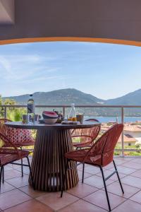 einen Tisch und Stühle auf einem Balkon mit Meerblick in der Unterkunft Résidence Ochji di Mare in Propriano