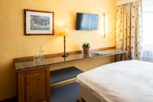 a hotel room with a desk with a bed at Cristallo Arosa Hotel in Arosa