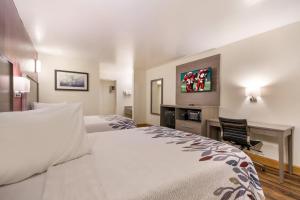 a hotel room with two beds and a tv at Red Roof Inn Crestview in Crestview