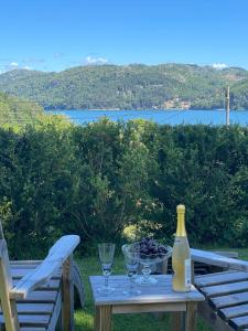 a table with wine glasses and a bottle of wine at Jåsund SunView in Lyngdal
