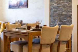 a dining room table with chairs and wine glasses at Mond Apartman in Zlatibor