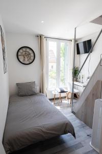 - une chambre avec un grand lit et un bureau dans l'établissement Warm Studio en duplex proche Paris et Disney, à Neuilly-Plaisance