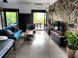 a living room with a blue couch and a stone wall at Anchor house in Volos