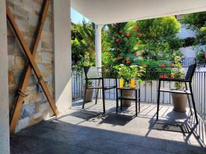 two chairs and a table on a balcony with flowers at Anchor house in Volos
