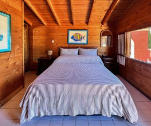 a bedroom with a bed in a wooden cabin at Aeneas' Landing Resort in Gaeta