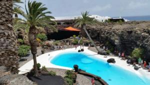 a swimming pool in a resort with people standing around it at Apto Punta Mujeres LAS ROSAS in Punta Mujeres