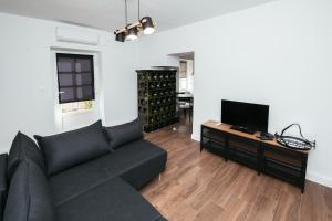 uma sala de estar com um sofá preto e uma televisão de ecrã plano em Barbarossa em Sveti Filip i Jakov