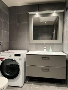 ein Badezimmer mit einer Waschmaschine und einem Waschbecken in der Unterkunft Fresh leilighet midt i Beitostølen sentrum in Beitostøl