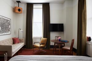 a hotel room with a bed and a table and a couch at Nine Orchard in New York