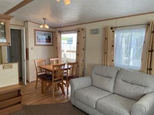 a living room with a couch and a table at Aaranmore Mobile Home in Portrush