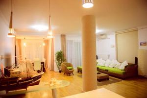 a living room with a green couch and a table at Sadara Sea Breeze in Mamaia Sat/Năvodari