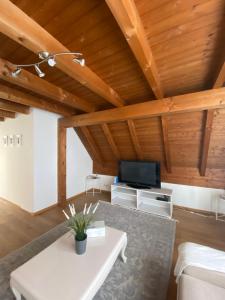 a living room with wooden ceilings and a white table at Get Cozy Family Flat Zürich in Zurich