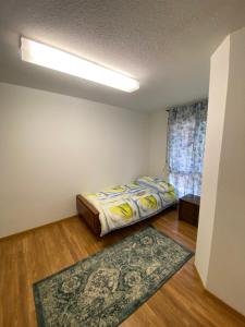 - une chambre avec un lit et un tapis au sol dans l'établissement Get Cozy Family Flat Zürich, à Zurich