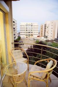 two chairs and a glass table on a balcony at Sadara Sea Breeze in Mamaia Sat/Năvodari