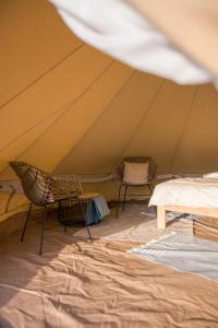 ein Zelt mit zwei Stühlen und einem Bett darin in der Unterkunft Stan u.nás in Dolní Řasnice